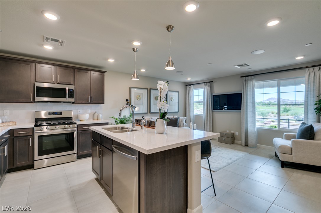 653 Pickled Pepper Place Henderson, NV 89011 - Photo 17 of 35 An inviting open-concept kitchen and living area, complete with an island and ample space for entertaining.