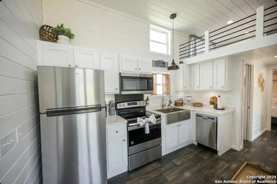 5386 Ranch Road 1376, Unit 97 Fredericksburg, TX 78624 - Photo 7 of 27 a kitchen with stainless steel appliances a refrigerator sink and cabinets