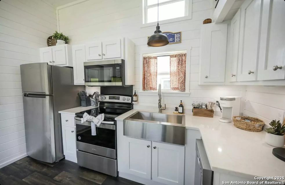 5386 Ranch Road 1376, Unit 97 Fredericksburg, TX 78624 - Photo 9 of 27 a kitchen with a refrigerator a stove a microwave and cabinets