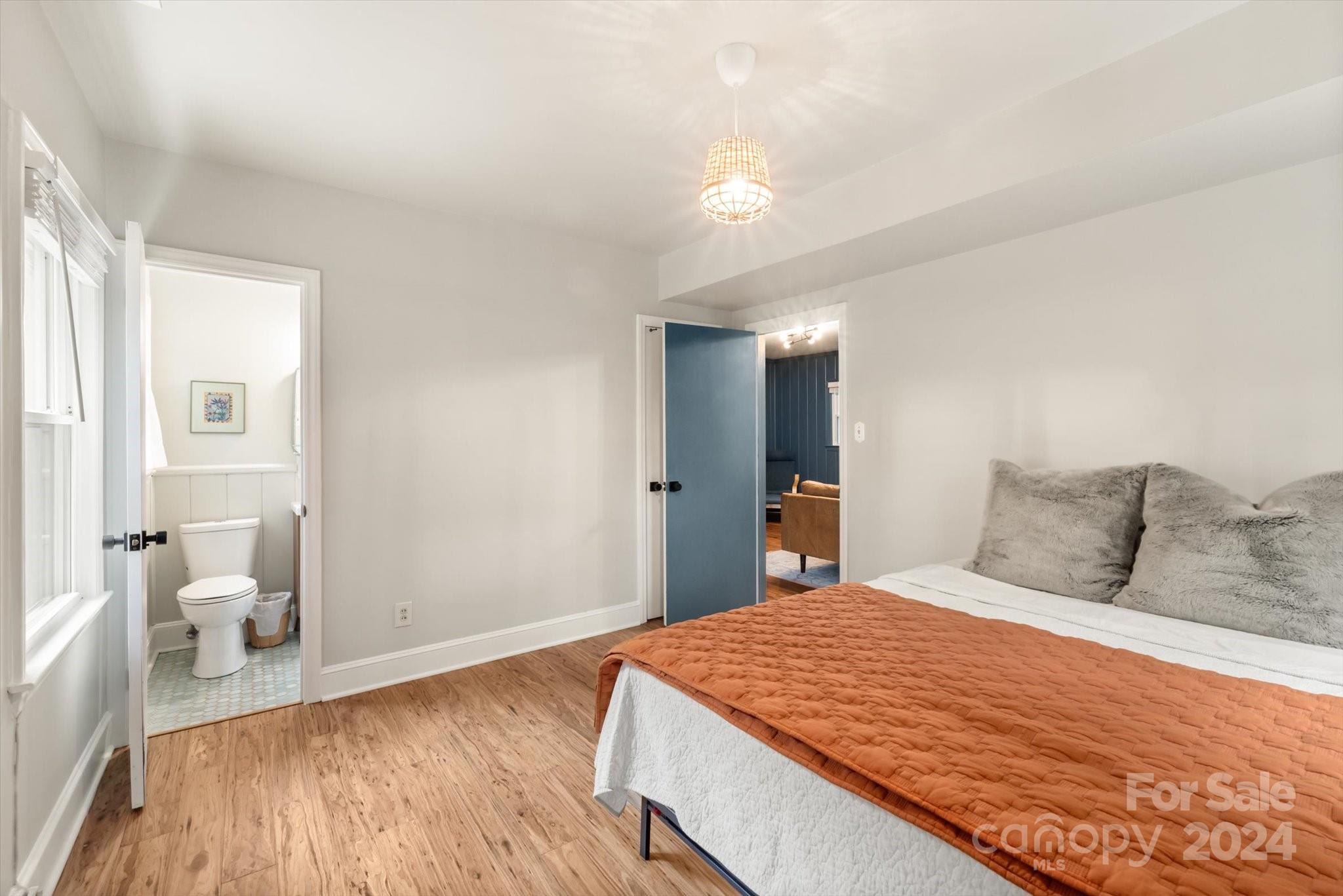 5822 Brookhaven Road Charlotte, NC 28210 - Photo 35 of 48 a bedroom with a large bed and a chandelier