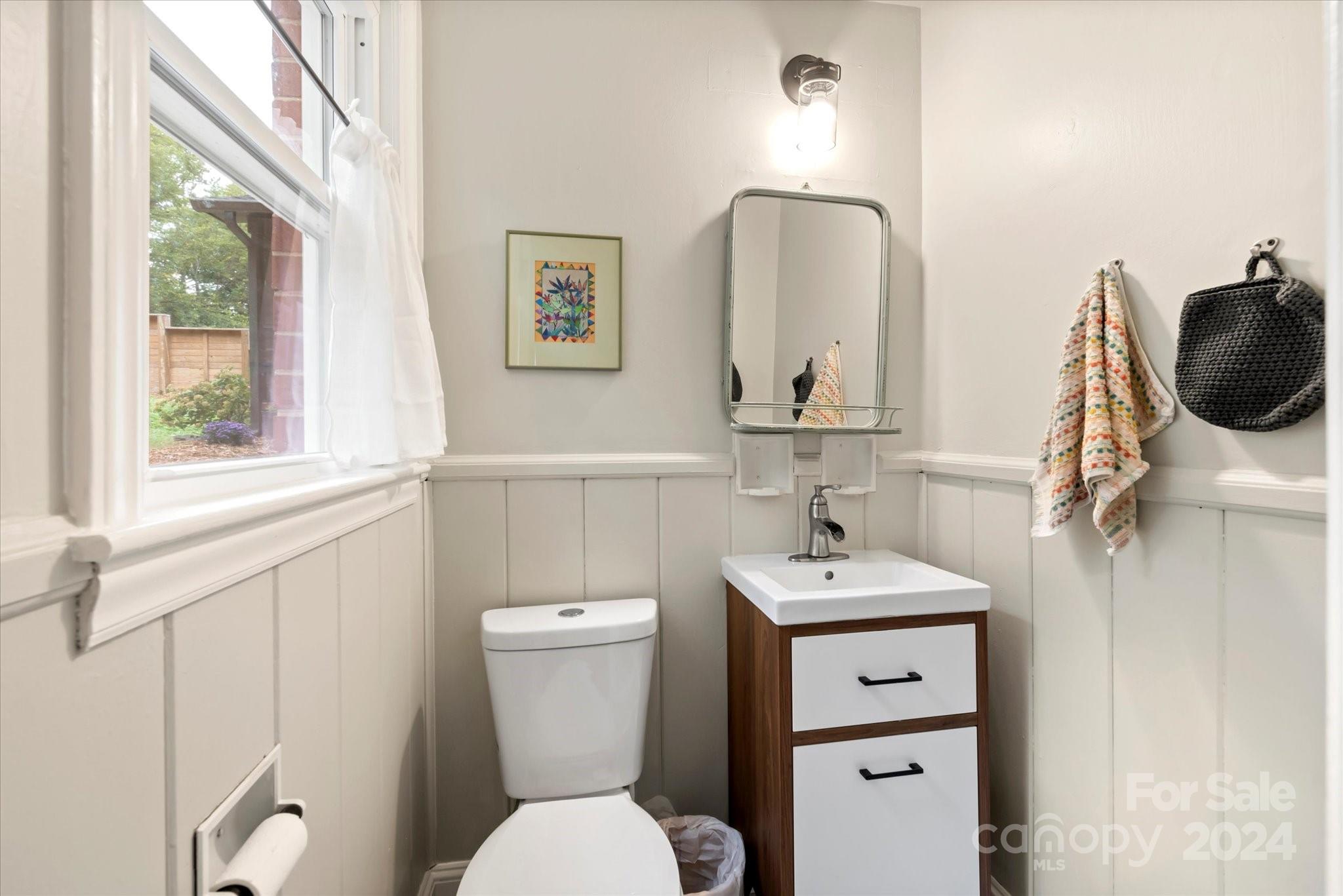 5822 Brookhaven Road Charlotte, NC 28210 - Photo 36 of 48 a bathroom with a toilet sink and mirror