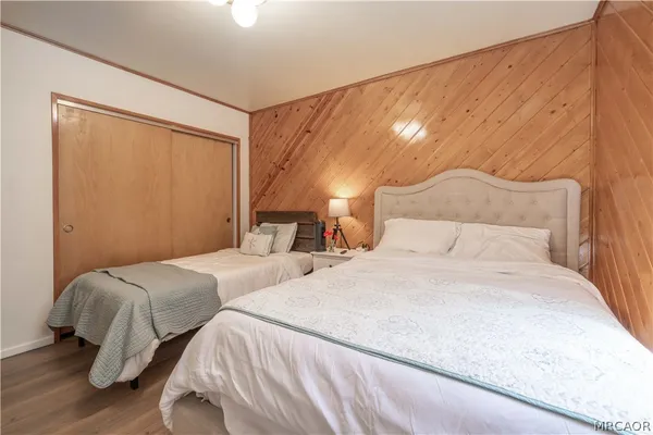 a bedroom with two beds and wooden floor