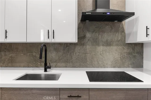 a kitchen with stainless steel appliances granite countertop a refrigerator a sink and white cabinets