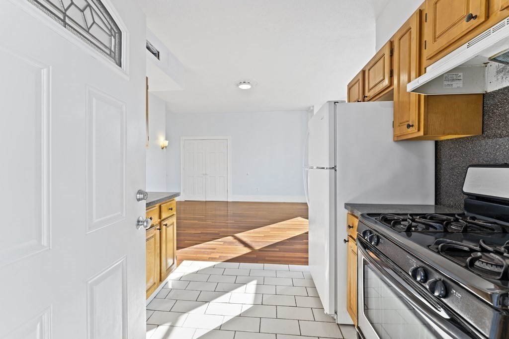 515 R Norfolk Street Boston, MA 02126 - Photo 11 of 26 a kitchen with stainless steel appliances granite countertop a stove and a refrigerator