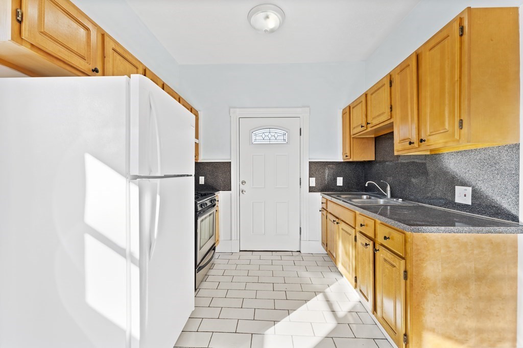 515 R Norfolk Street Boston, MA 02126 - Photo 15 of 26 a kitchen with a sink a refrigerator and a stove