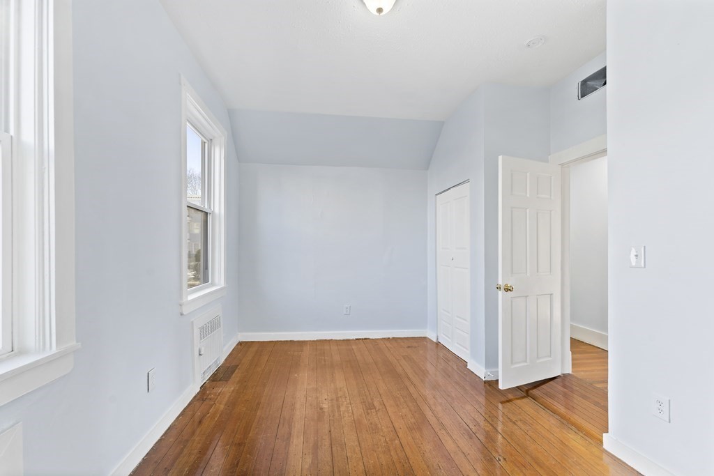 515 R Norfolk Street Boston, MA 02126 - Photo 16 of 26 an empty room with wooden floor and windows