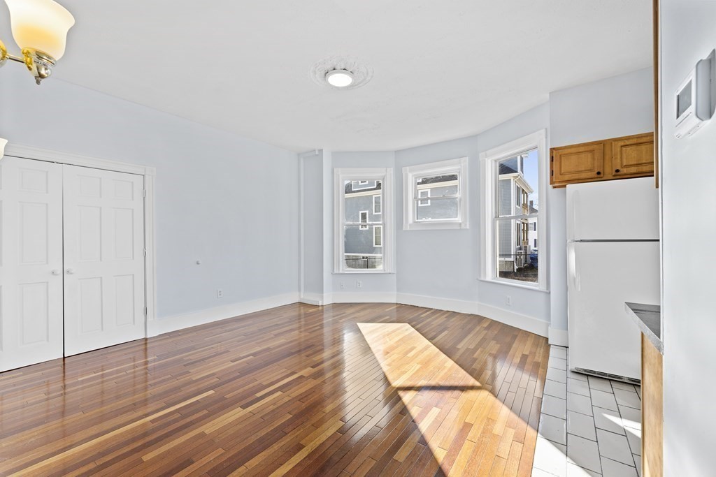 515 R Norfolk Street Boston, MA 02126 - Photo 10 of 26 a view of a bedroom with wooden floor and a window