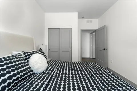 a bedroom with a bed wooden floor and a window