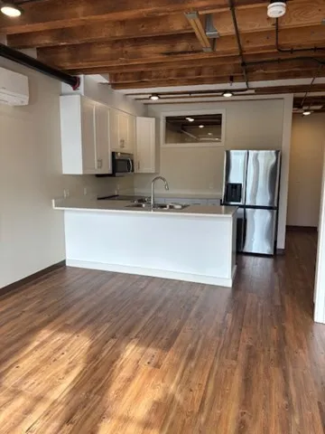 a view of a refrigerator in kitchen and wooden floor