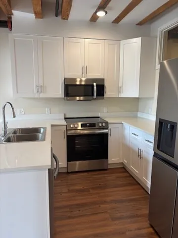 a kitchen with stainless steel appliances a stove a sink and a microwave