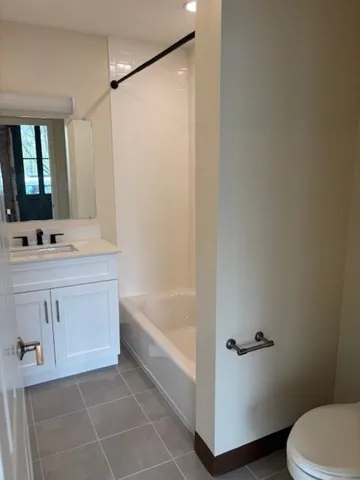 a bathroom with a bathtub a sink a toilet and a mirror