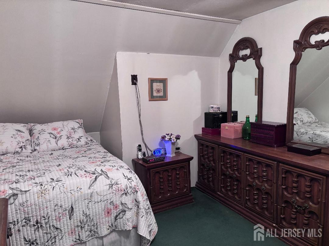 490 Mckeon Street Perth Amboy, NJ 08861 - Photo 19 of 28 a bedroom with a bed and dresser with mirror