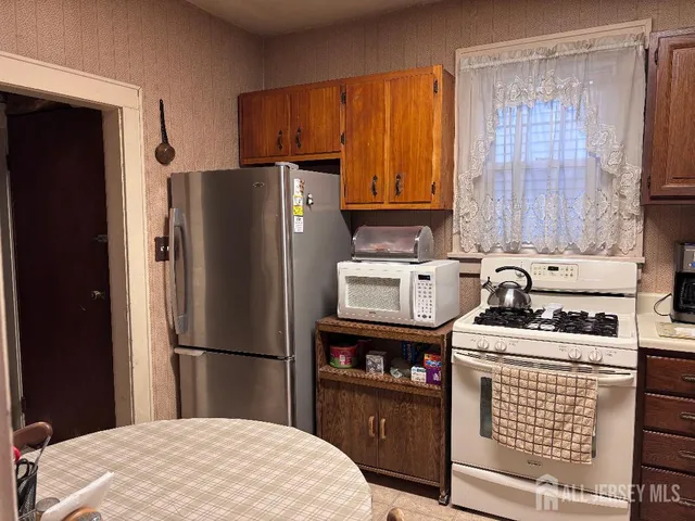 a kitchen with stainless steel appliances granite countertop a refrigerator stove and sink