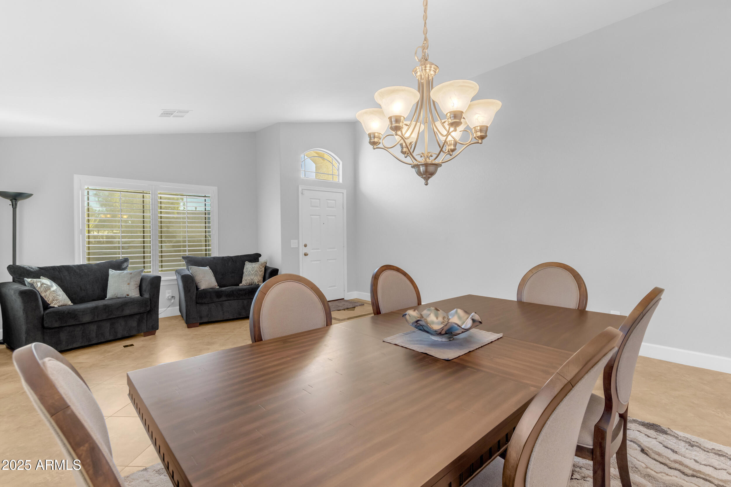 13438 West Redfield Road Surprise, AZ 85379 - Photo 14 of 75 a view of a dining room with furniture a chandelier and wooden floor