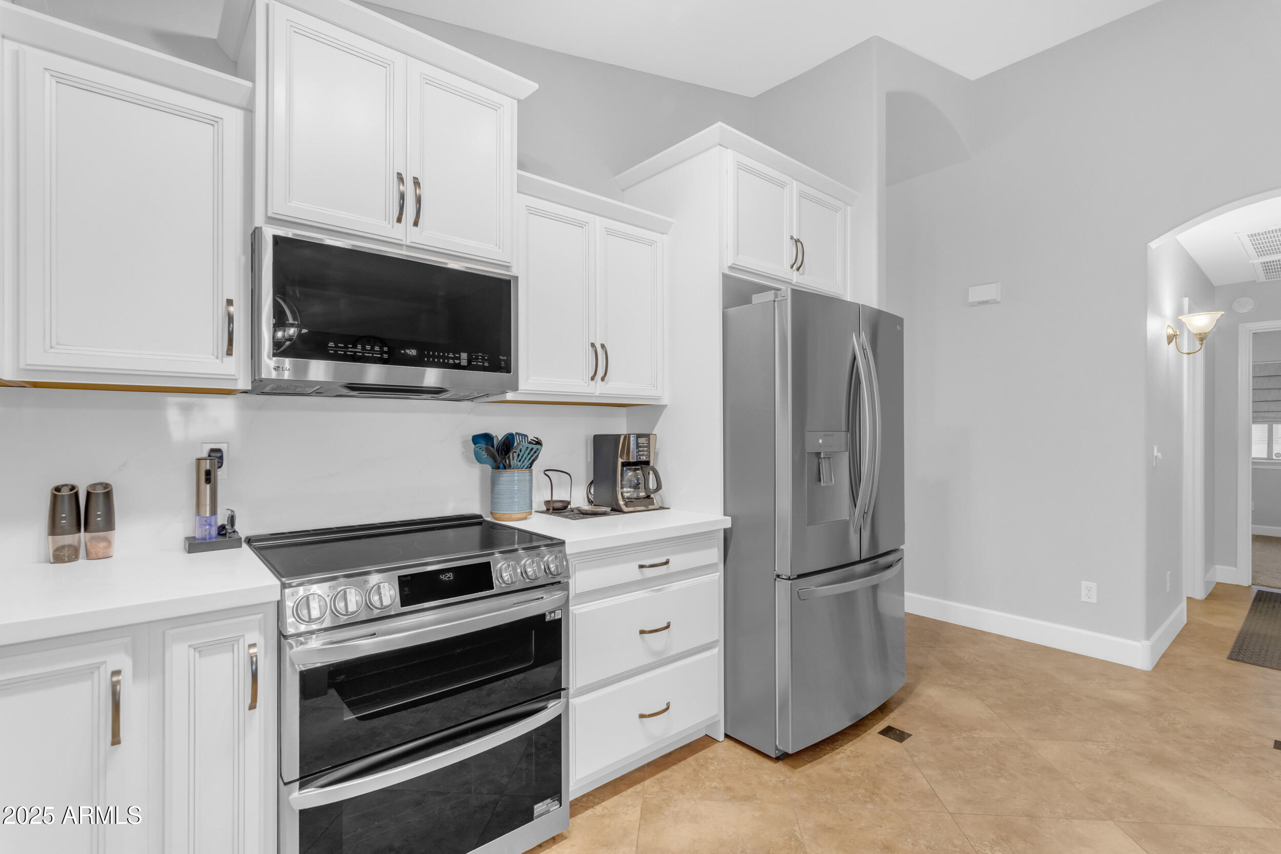 13438 West Redfield Road Surprise, AZ 85379 - Photo 22 of 75 a kitchen with white cabinets and stainless steel appliances
