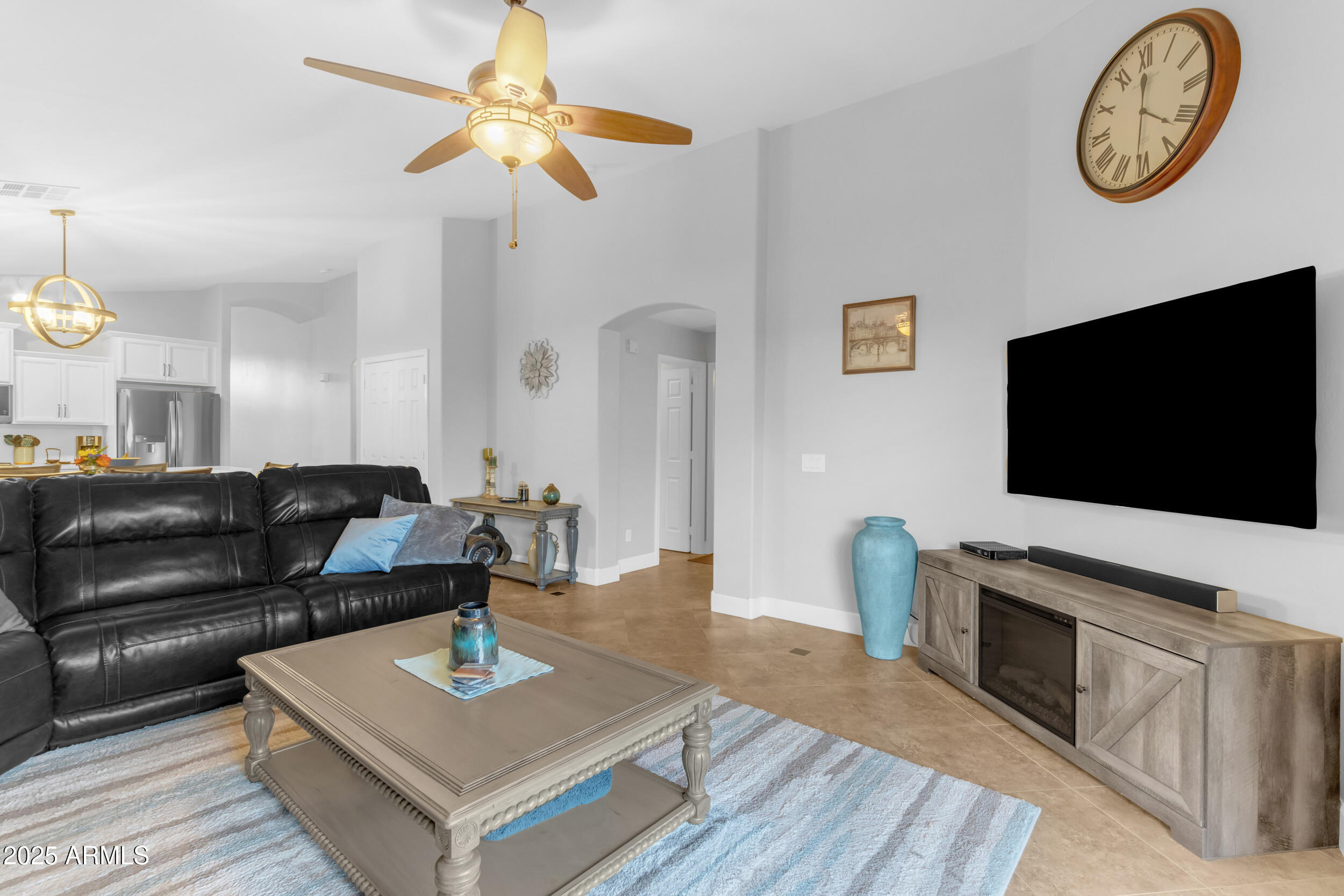 13438 West Redfield Road Surprise, AZ 85379 - Photo 34 of 75 a living room with furniture a flat screen tv and a fireplace