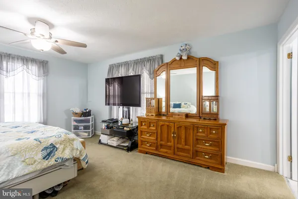 a spacious bedroom with a bed furniture and a chandelier