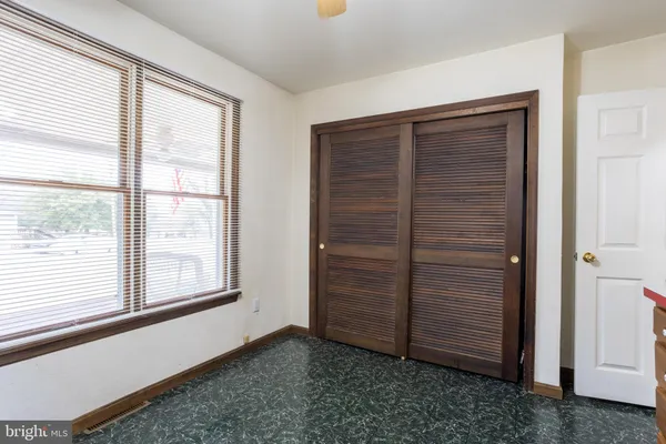 en empty room with windows and ceiling fan