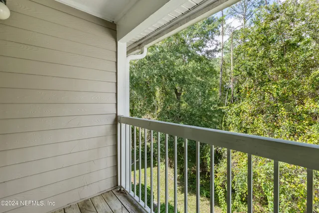 a view of swimming pool with seating area and trees in the background