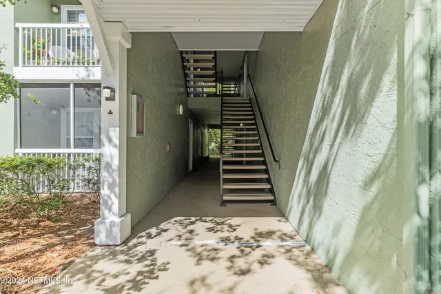 a view of a hallway with wooden floor and stairs