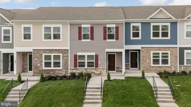 a front view of a house with yard and green space
