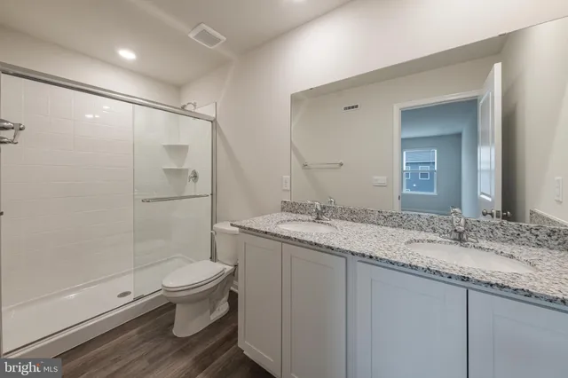 a bathroom with a granite countertop sink toilet and shower