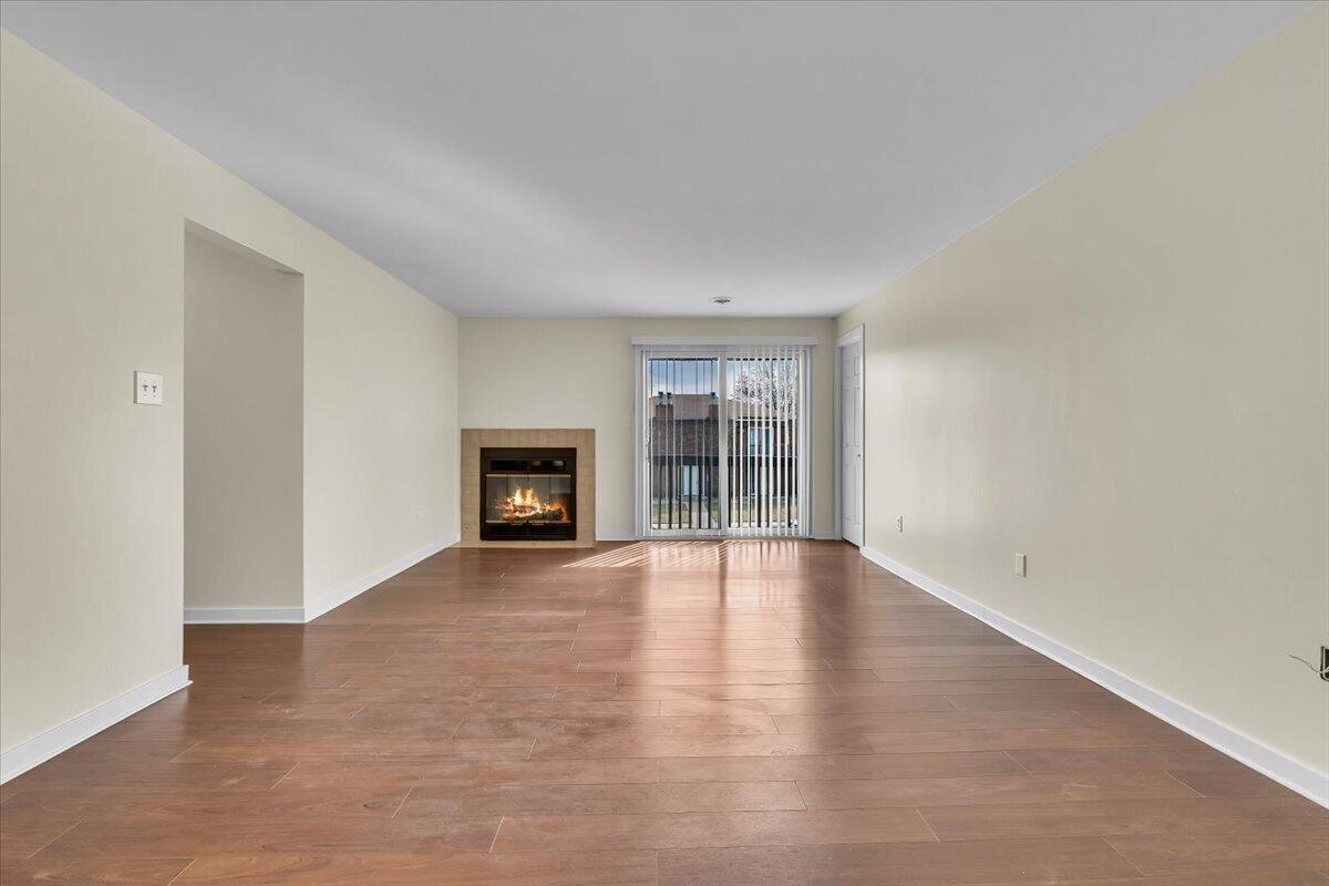 1444 Woodview Drive, Unit 7 Crown Point, IN 46307 - Photo 4 of 15 a view of an empty room with wooden floor and a window
