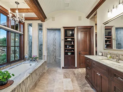 a spacious bathroom with a granite countertop tub sink and mirror