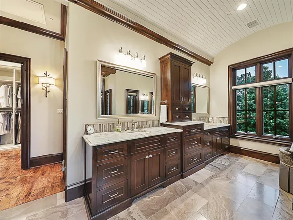 a spacious bathroom with a granite countertop double vanity and a mirror