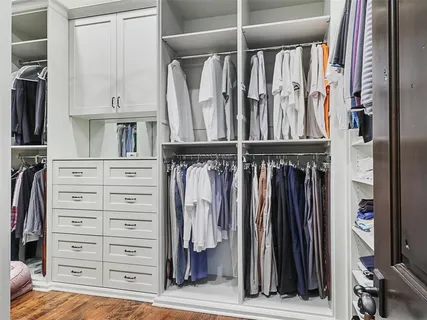 a view of walk in closet with clothes and shoes