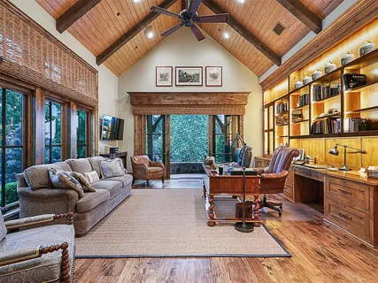 a living room with furniture a fireplace and a large window