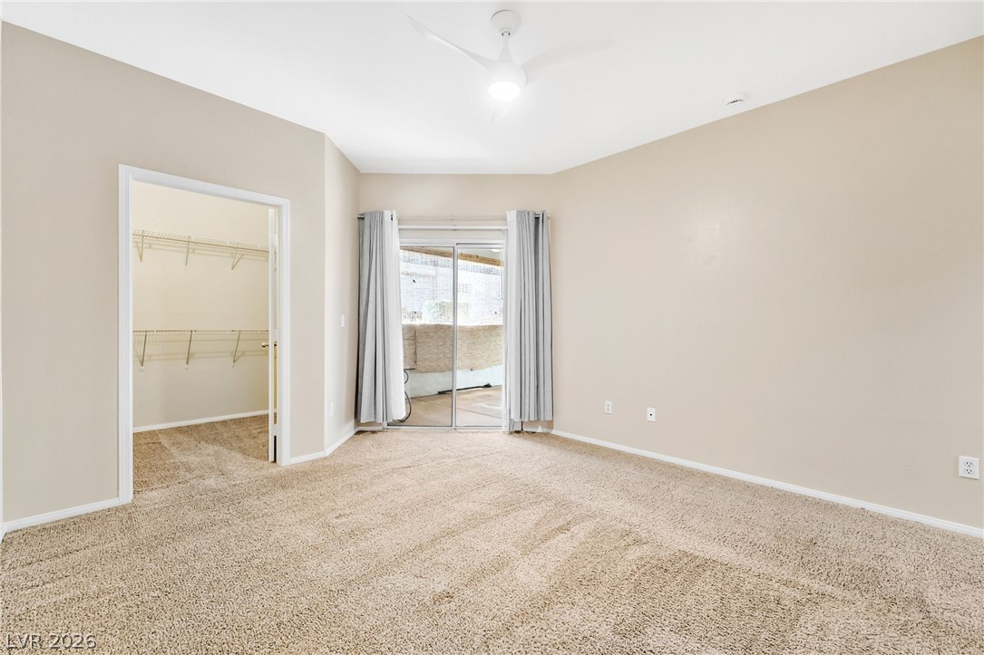 2050 West Warm Springs Road, Unit 2411 Henderson, NV 89014 - Photo 17 of 37 Well-lit room with ample space, offering direct outdoor access through sliding glass doors.