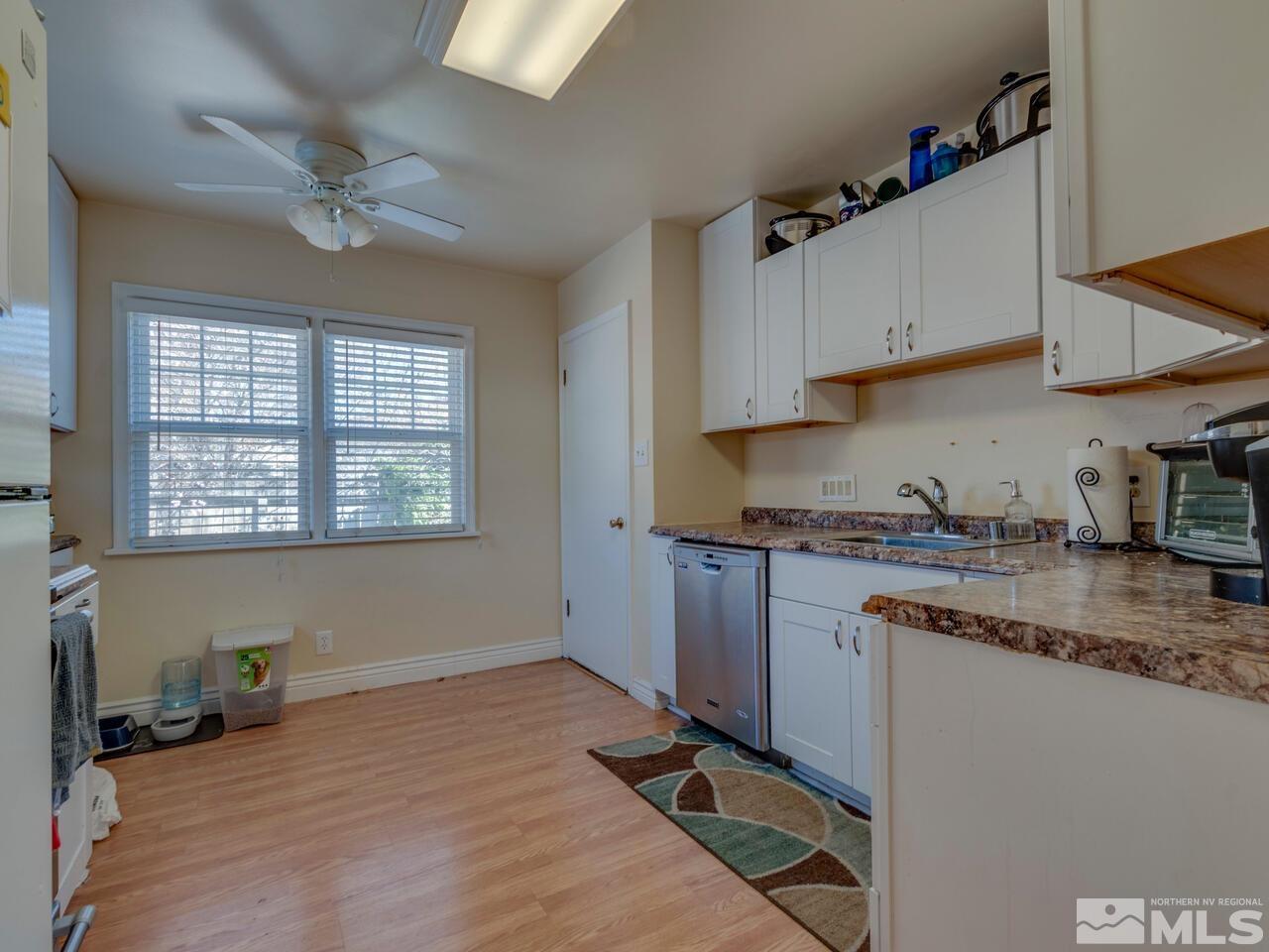 1061 Whitaker Drive Reno, NV 89503 - Photo 8 of 20 a kitchen with granite countertop a stove a sink dishwasher and cabinets with wooden floor