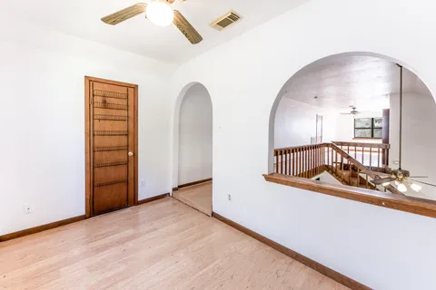 a view of an empty room with window and wooden floor