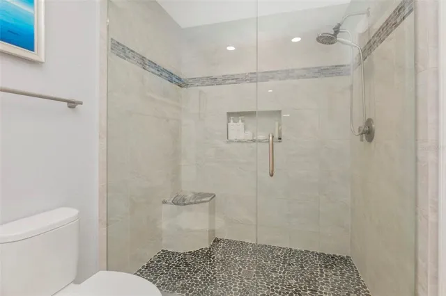 a bathroom with a shower a toilet and a shower