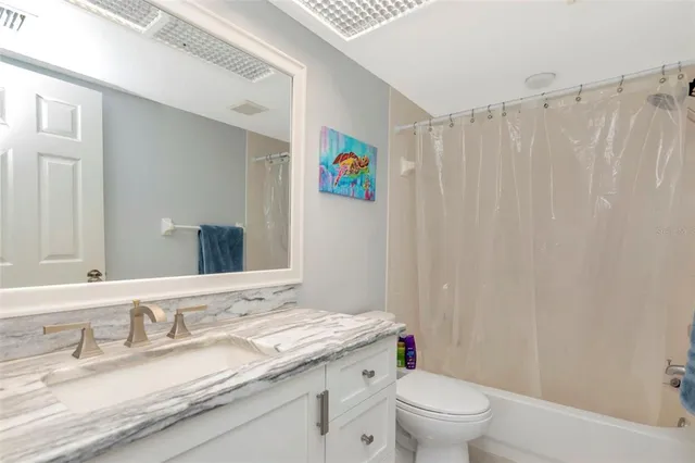 a bathroom with a granite countertop sink a toilet and a mirror