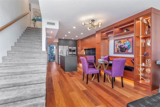 a view of a dining room with furniture a rug and wooden floor