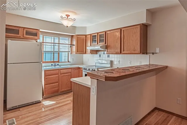a kitchen with a stove a refrigerator and a sink