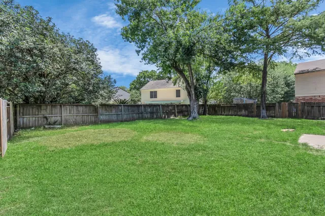 a view of a house with backyard and a tree