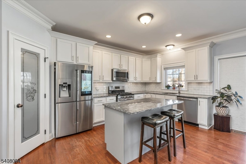 177 Maple Street Bridgewater, NJ 08807 - Photo 4 of 37 a kitchen with stainless steel appliances white cabinets and wooden floor