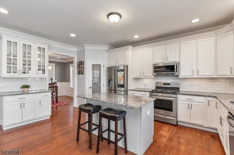 177 Maple Street Bridgewater, NJ 08807 - Photo 5 of 37 a kitchen with stainless steel appliances granite countertop a stove top oven a sink dishwasher and a refrigerator with wooden floor