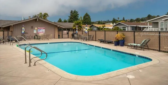 a view of a house with pool and chairs