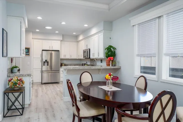 a kitchen with stainless steel appliances a dining table and chairs