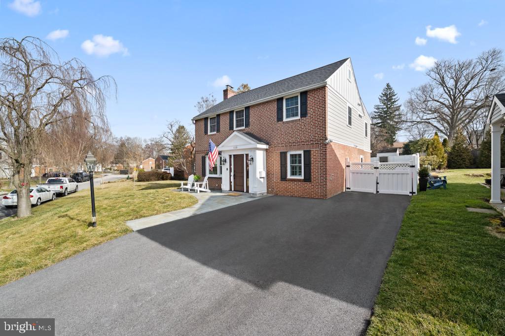 a front view of a house with a yard and tree s