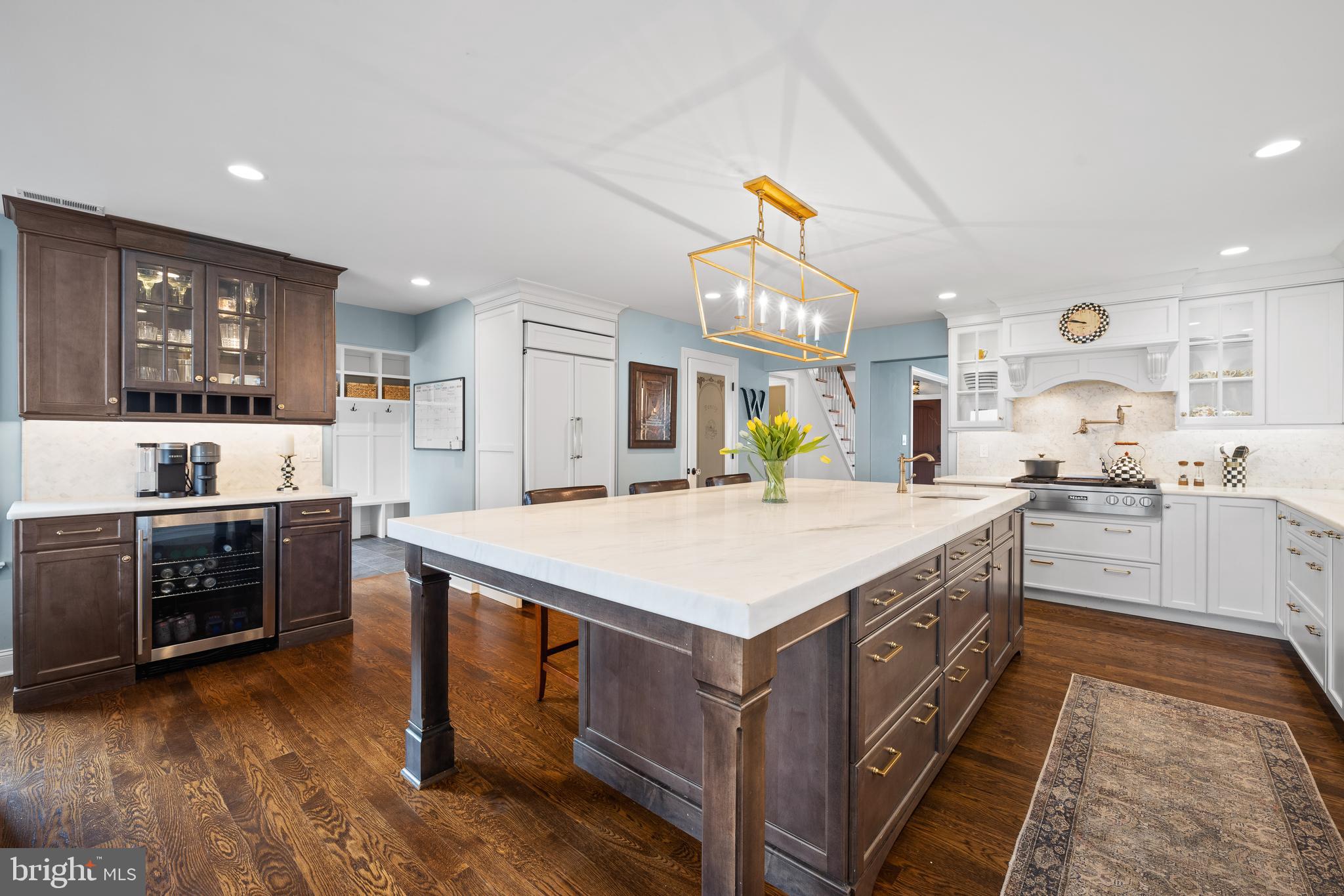 115 Barcladen Road Bryn Mawr, PA 19010 - Photo 12 of 39 a large kitchen with kitchen island a stove a sink a refrigerator and a dining table with wooden floor