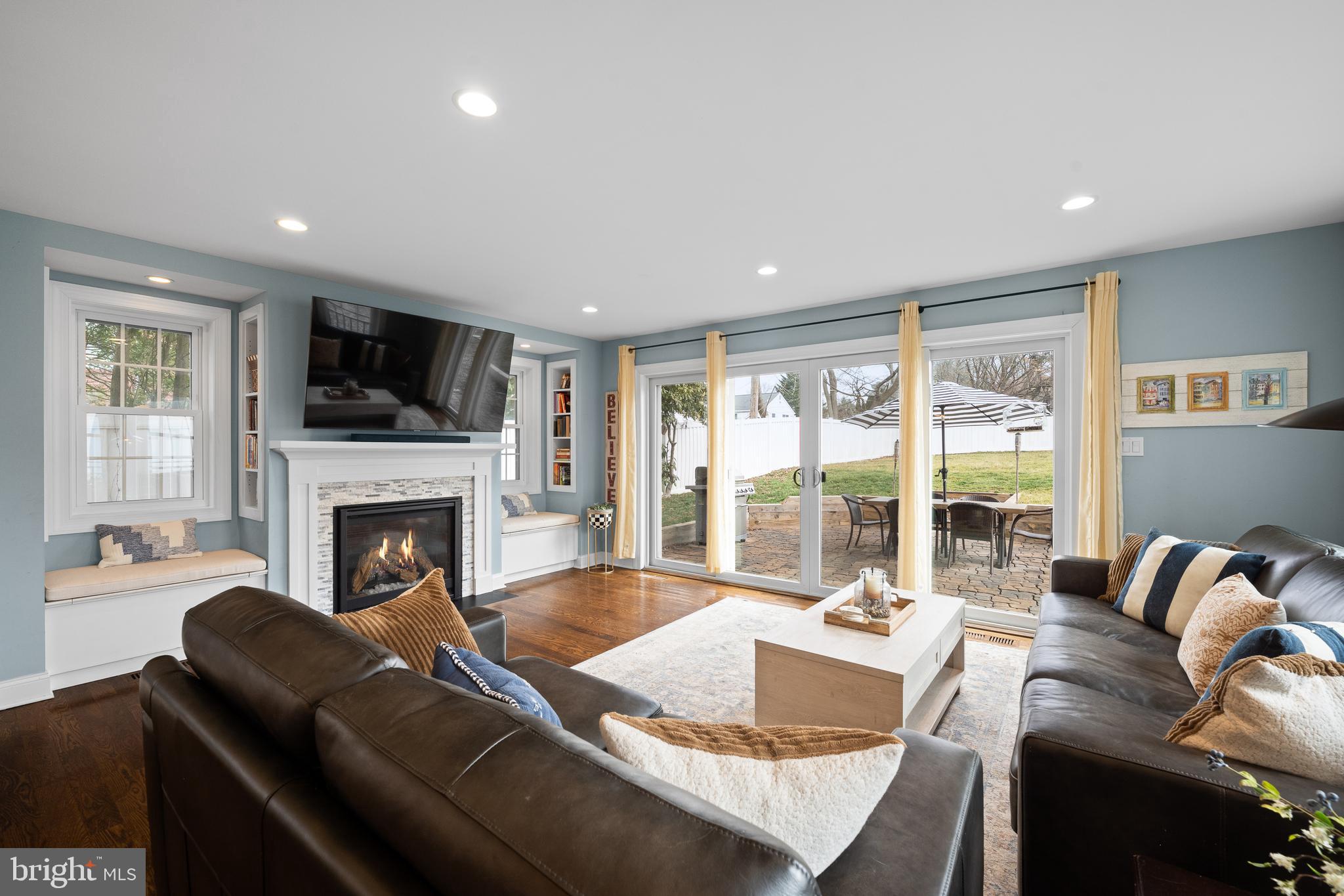 115 Barcladen Road Bryn Mawr, PA 19010 - Photo 8 of 39 a living room with furniture large windows and a fireplace