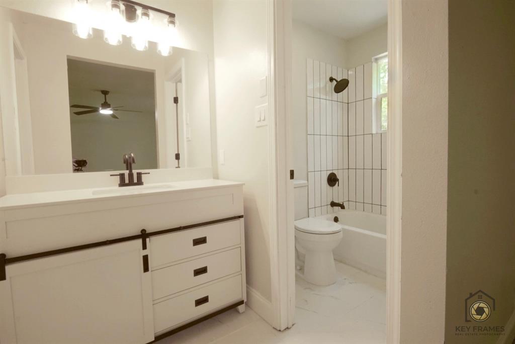9227 Walker Road Shreveport, LA 71118 - Photo 14 of 16 a bathroom with a double vanity sink toilet and mirror