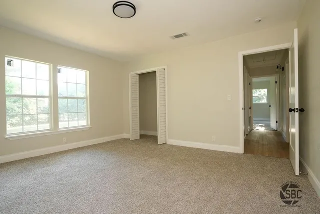 an empty room with windows and closet