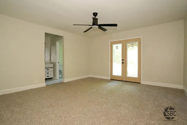 an empty room with closet and windows
