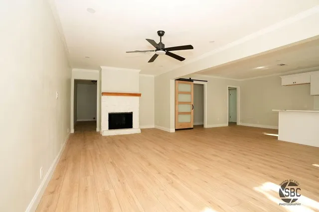 a view of a livingroom with a fireplace and a ceiling fan